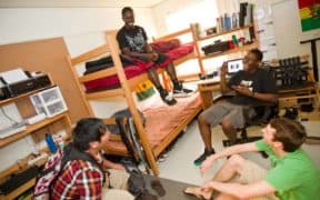 happy college roommates laughing in dorm room